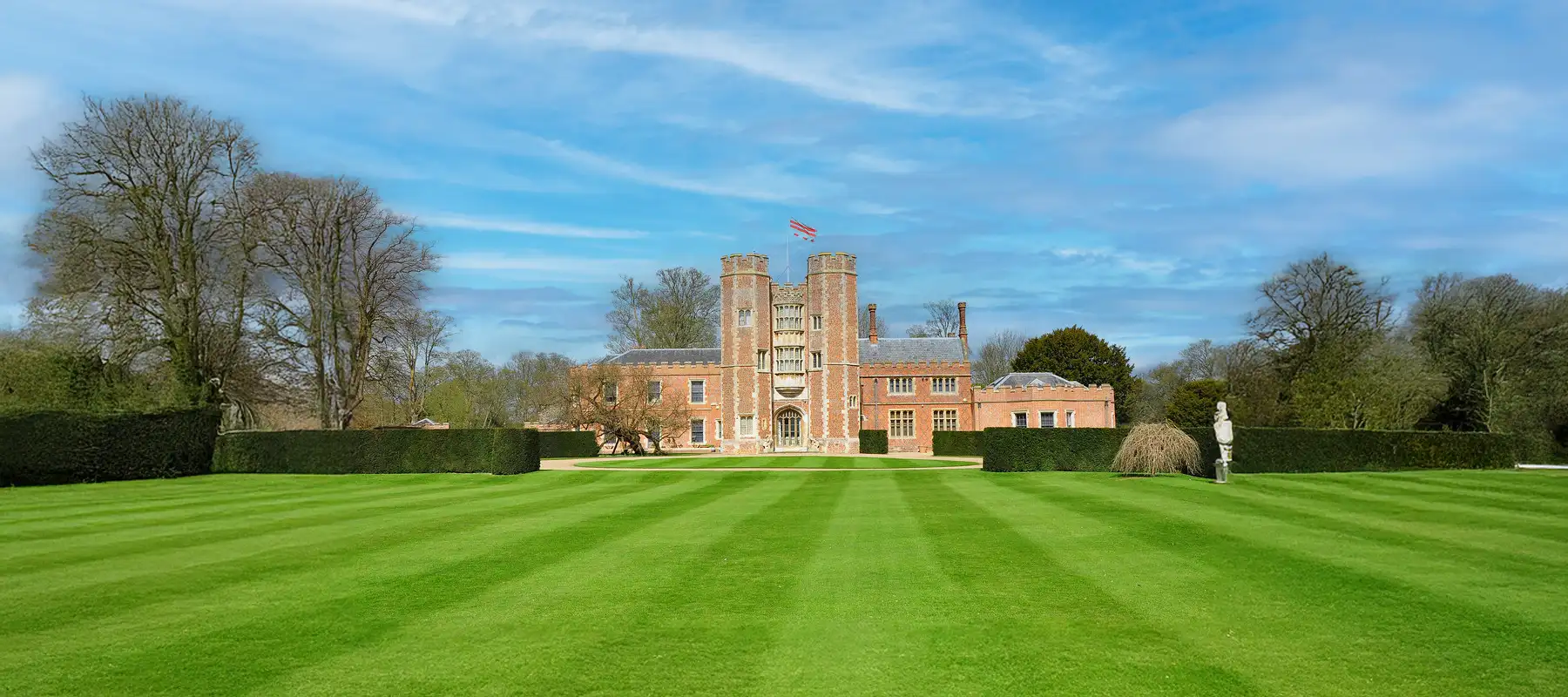 Building with two towers and a beautifully manicured lawn